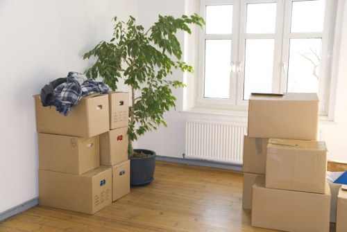 Specialist movers handling a grand piano move with protective equipment in a Chiswick property